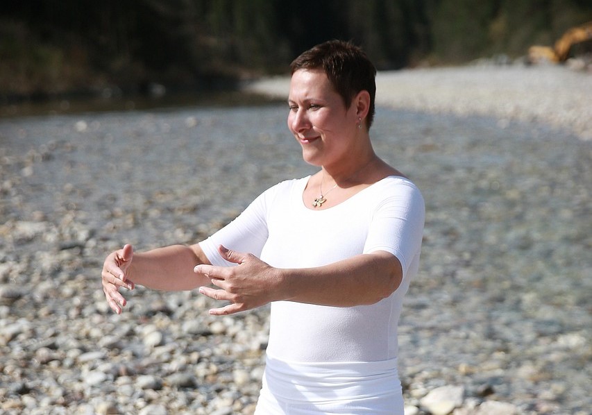Kobieta ćwicząca qigong medyczny nad rzeką – praktyka wspierająca krążenie limfy i zdrowie